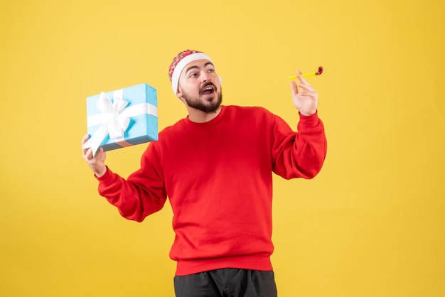 Free photo front view young male with xmas present on the yellow background