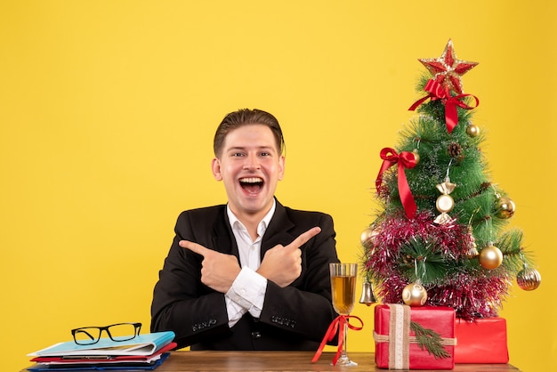 Front view young male worker sitting behind his table excited