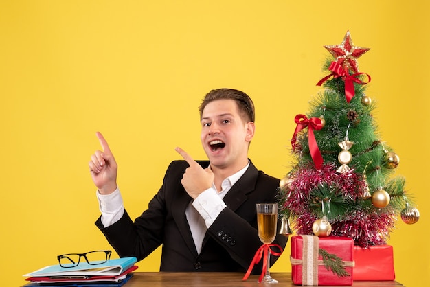 Front view young male worker sitting behind his table