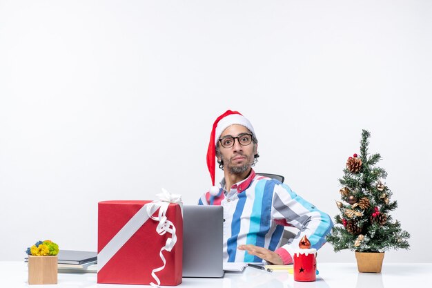 Free photo front view young male worker sitting in his working place on white background