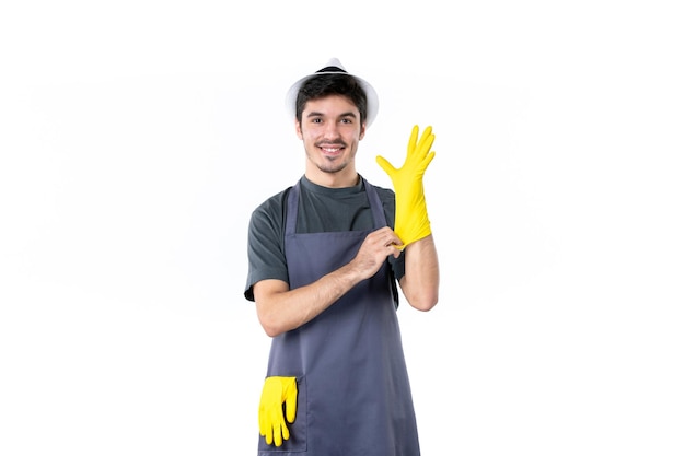 正面図白い背景に黄色の手袋で若い男性フラワーガーデン仕事庭師木草ブッシュ植物