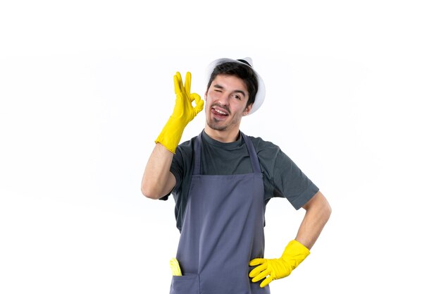 正面図白い背景に黄色の手袋で若い男性花草ブッシュ植物仕事庭の木庭師