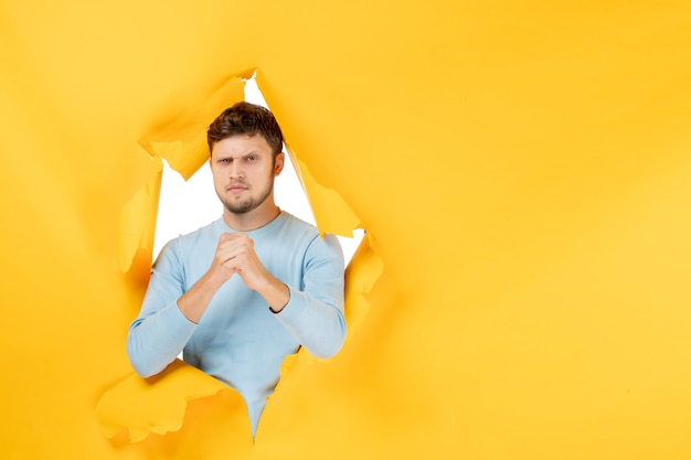 Free photo front view young male on yellow ripped background