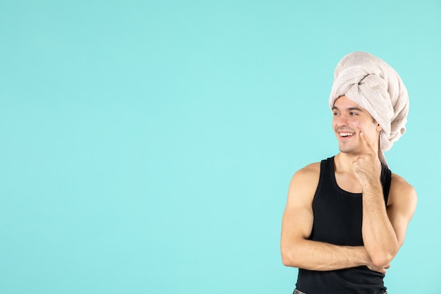 front view of young man after shower on blue wall