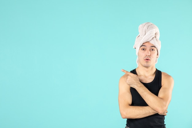 front view of young man after shower on blue wall