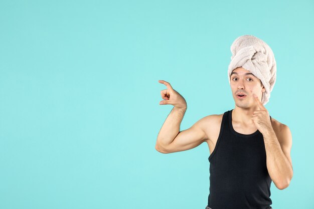 front view of young man after shower on blue wall