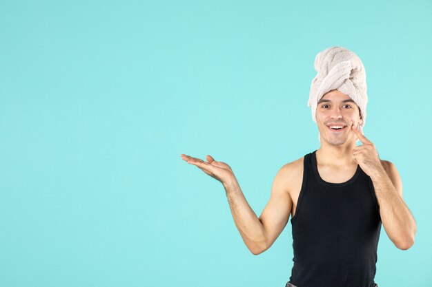 front view of young man after shower on blue wall