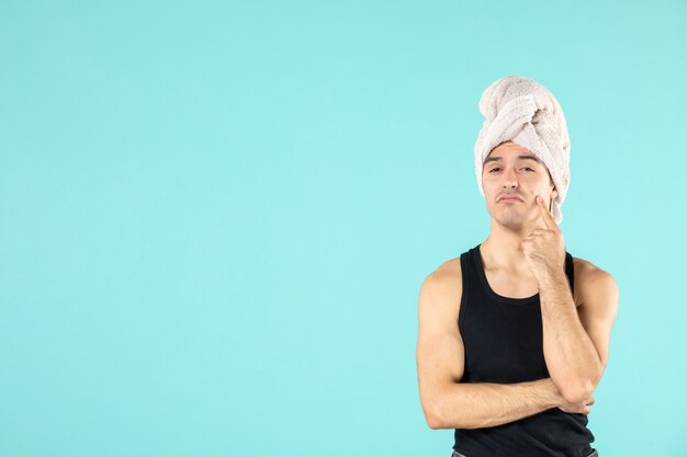 front view of young man after shower on blue wall