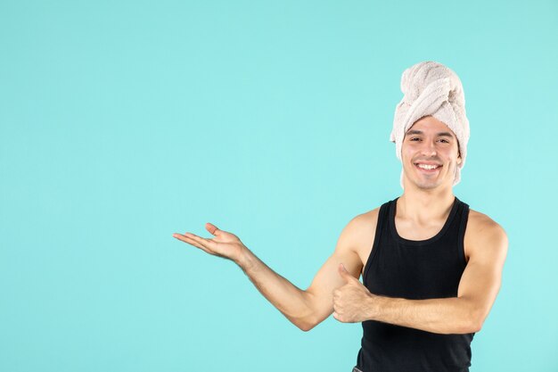 front view of young man after shower on blue wall