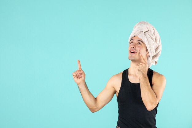 front view of young man after shower on blue wall