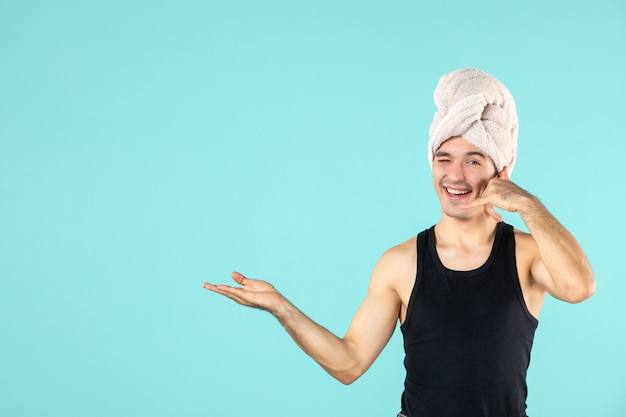 front view of young man after shower on blue wall