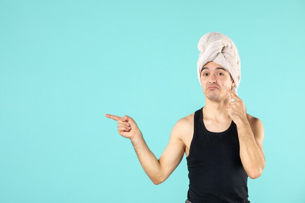 front view of young man after shower on blue wall