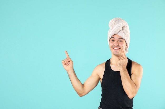 Free photo front view of young man after shower smiling on a blue wall