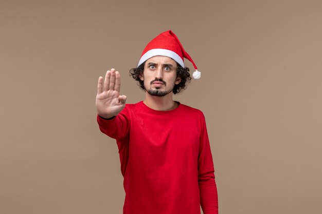 Front view young man asking to stop on brown background christmas emotion holiday