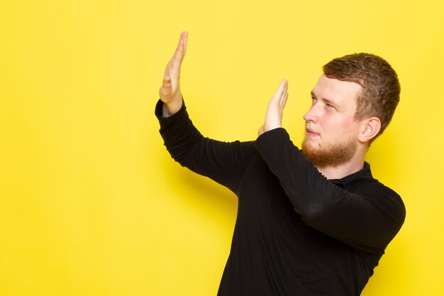 Front view of young man in black shirt posing cautiously