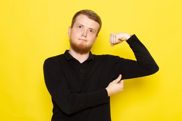 Front view of young man in black shirt posing and flexing