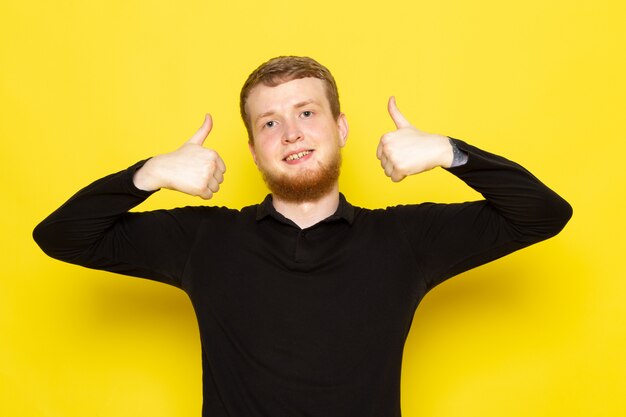 Front view of young man in black shirt posing and smiling