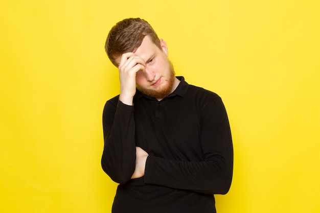 Front view of young man in black shirt posing and thinking