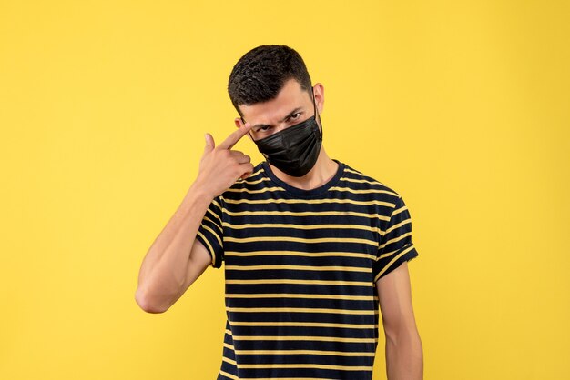 Front view young man in black and white striped t-shirt yellow background