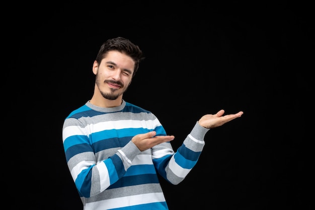 Front view young man in blue striped jersey presenting or showing a product