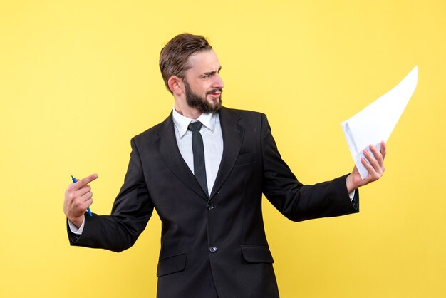Вид спереди бизнесмена молодого человека, возмущенно указывая пальцем на чистый лист бумаги на желтом
