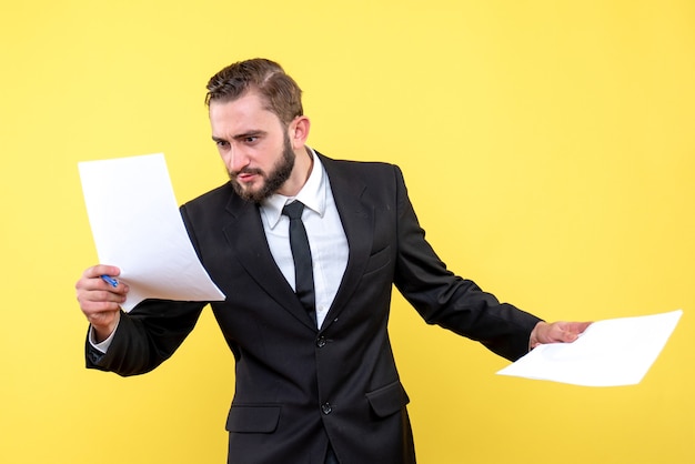 Front view of young man businessman quickly checking each document on yellow