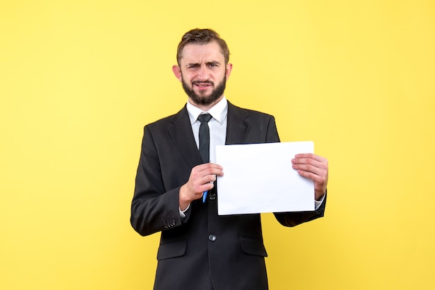 Front view of young man businessman in a suit is bewildered he strictly  makes a questioning on yellow