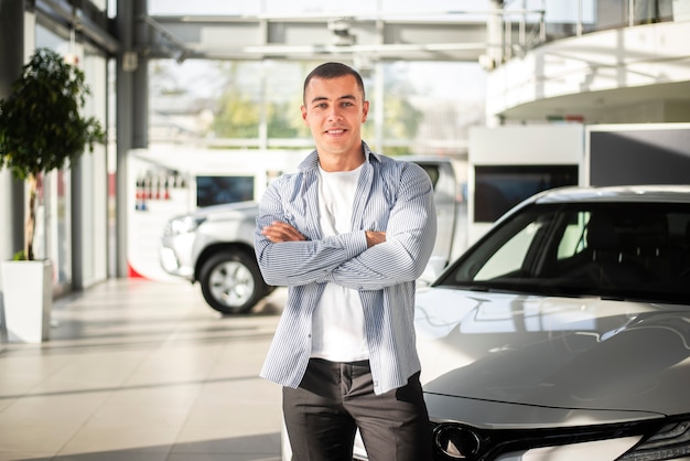 Foto gratuita vista frontale giovane a un concessionario di automobili