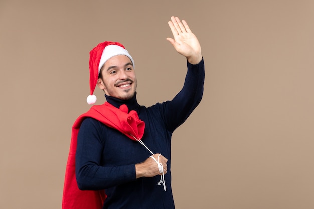 Free photo front view young man carrying present bag, christmas holiday santa