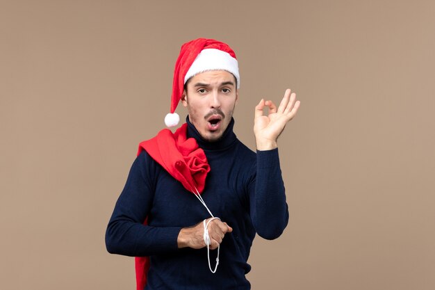 Front view young man carrying present bag, holiday christmas santa