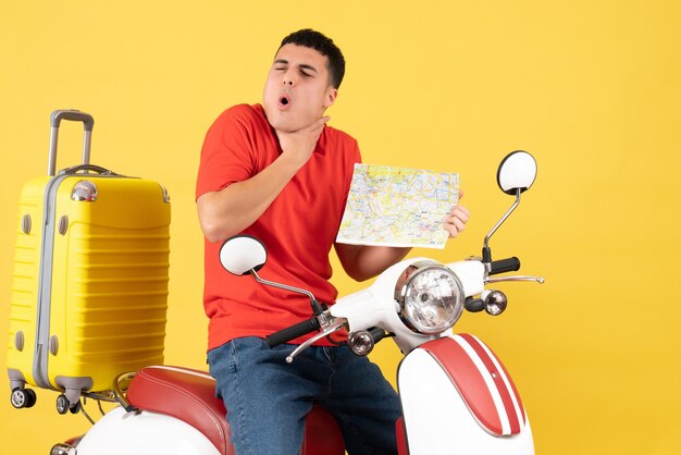 Вид спереди молодой человек в повседневной одежде на мопеде с картой путешествия, держащий горло от боли