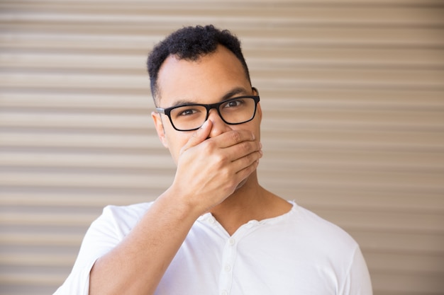 Free photo front view of young man covering mouth with hand