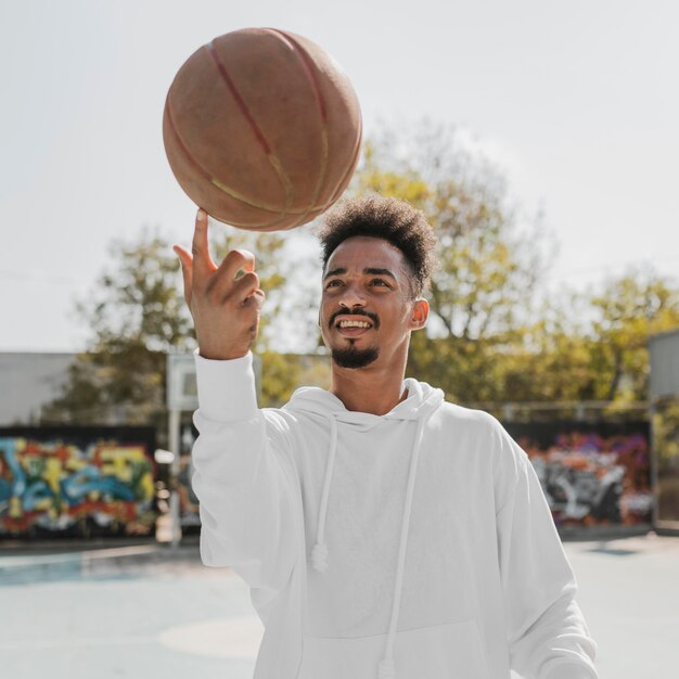 Front view young man doing tricks with a basketball