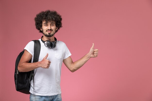 Front view young man doing two thumbs up with bag