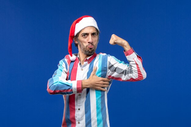 Front view young man flexing with excited face, emotion holiday male