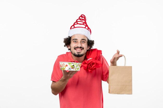 Front view of young man holding delivery food on white wall