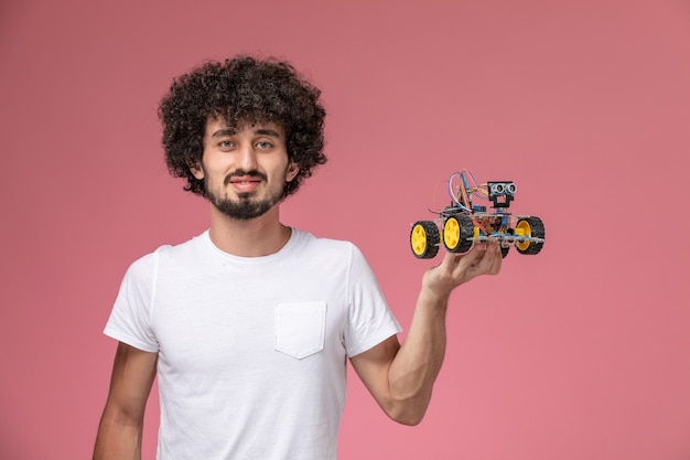 Front view young man holding his electronic robot