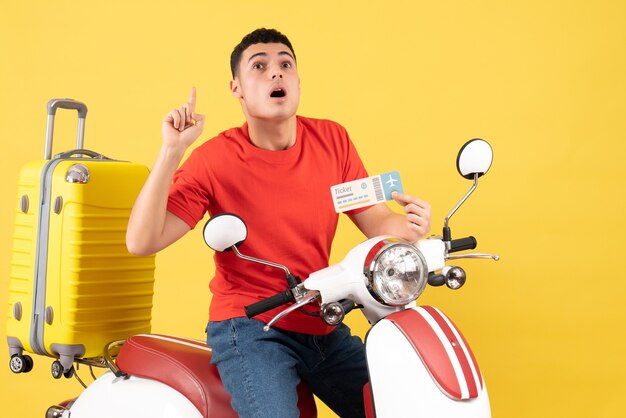 Front view young man on moped holding ticket surprising with an idea or question