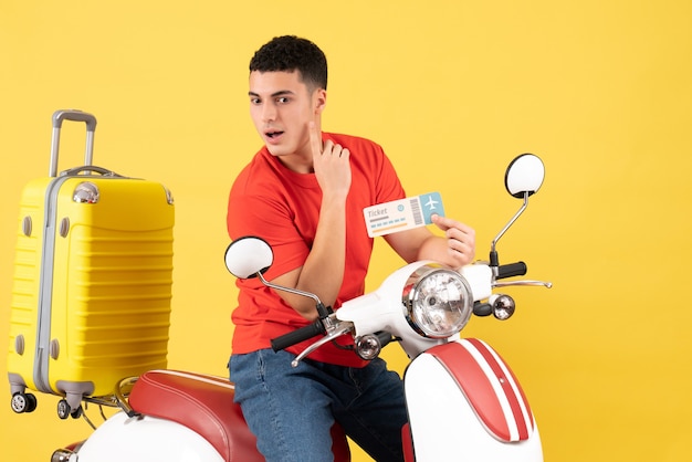 Front view young man on moped holding ticket thinking something