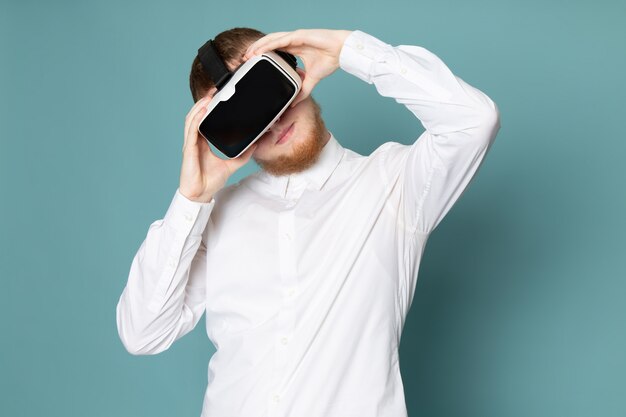 A front view young man playing vr in white t-shirt on the blue desk