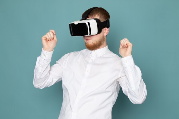 A front view young man playing vr in white t-shirt on the blue space