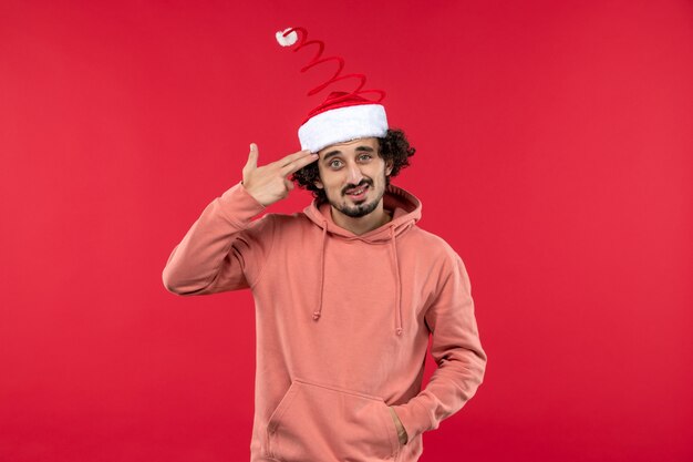 Front view of young man posing on red wall