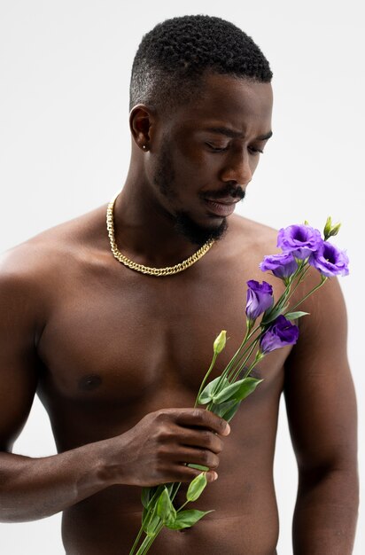 花でポーズをとる正面図若い男