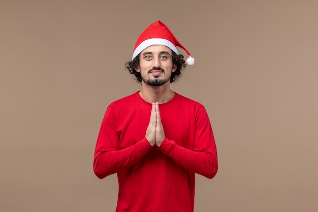 正面図茶色の背景で祈る若い男クリスマス感情休日