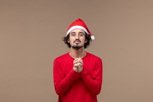 Front view young man praying on brown background holiday emotions christmas