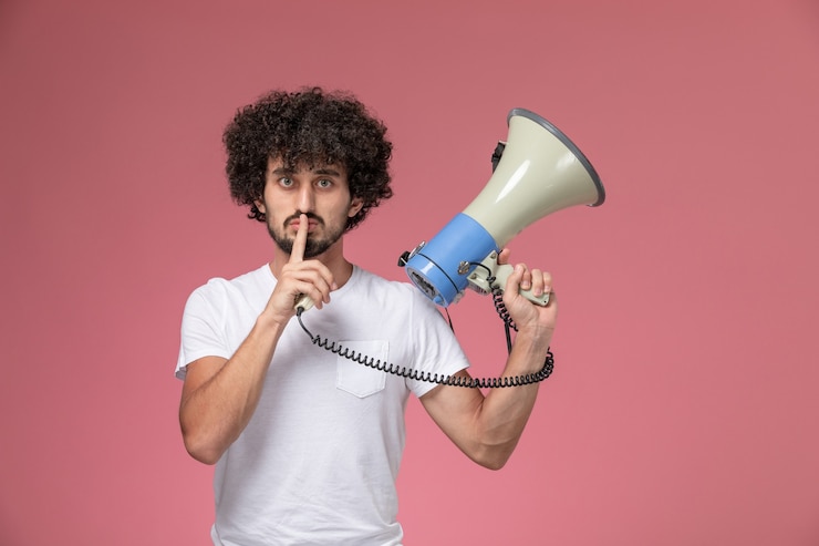 Free Photo front view young man showing keep silent gesture with hand microphone