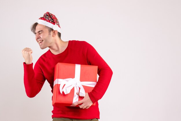 Front view young man showing winning gesture standing on white 