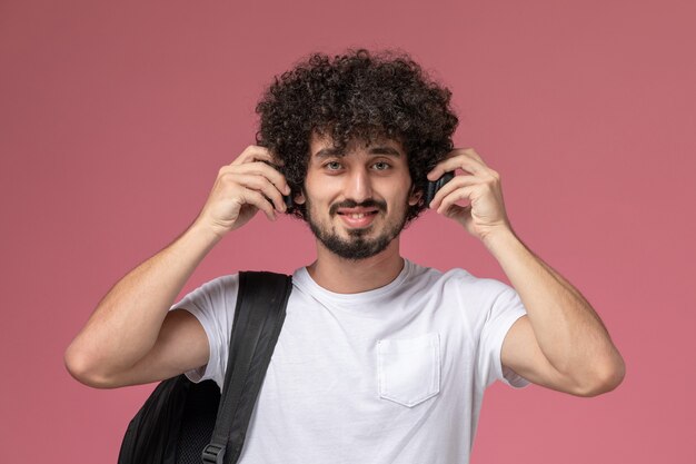 Front view young man smiling and listening to pop song