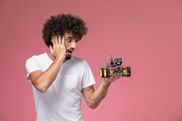 Front view young man surprising by his robotic innovation