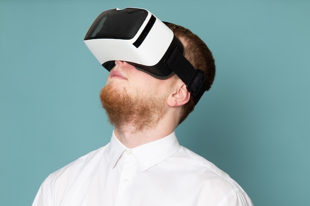A front view young man using vr on the blue floor